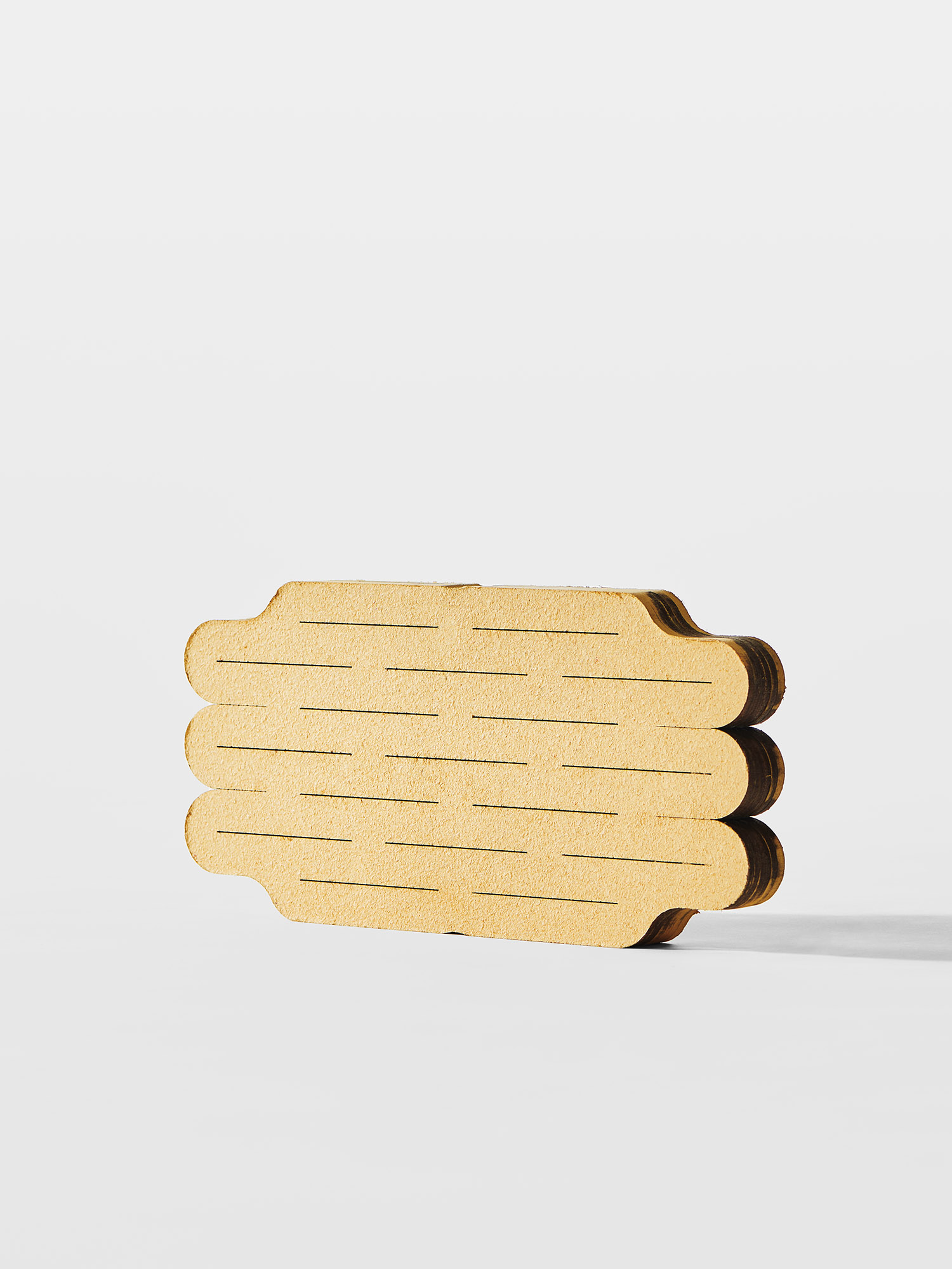 Chris Kabel<br><br>This stool’s design aims to create a very compact dried starting element. The cutting patterns in the manufactured plates allows the material to expand in two directions when moistened: vertically as well as horizontally. The vertical expansion is the material’s “natural” way of deploying; the horizontal one, however, needs to be forced, by inserting a small piece of wood the structure’s apertures during the drying period. If, on one hand, the use of a foreign element in the process can be seen as a complication or a downside, on the other hand, it provides a shortened drying time. Moreover, the stool answers perfectly to the research’s primary objective, creating an object that occupies a fraction of its final volume.